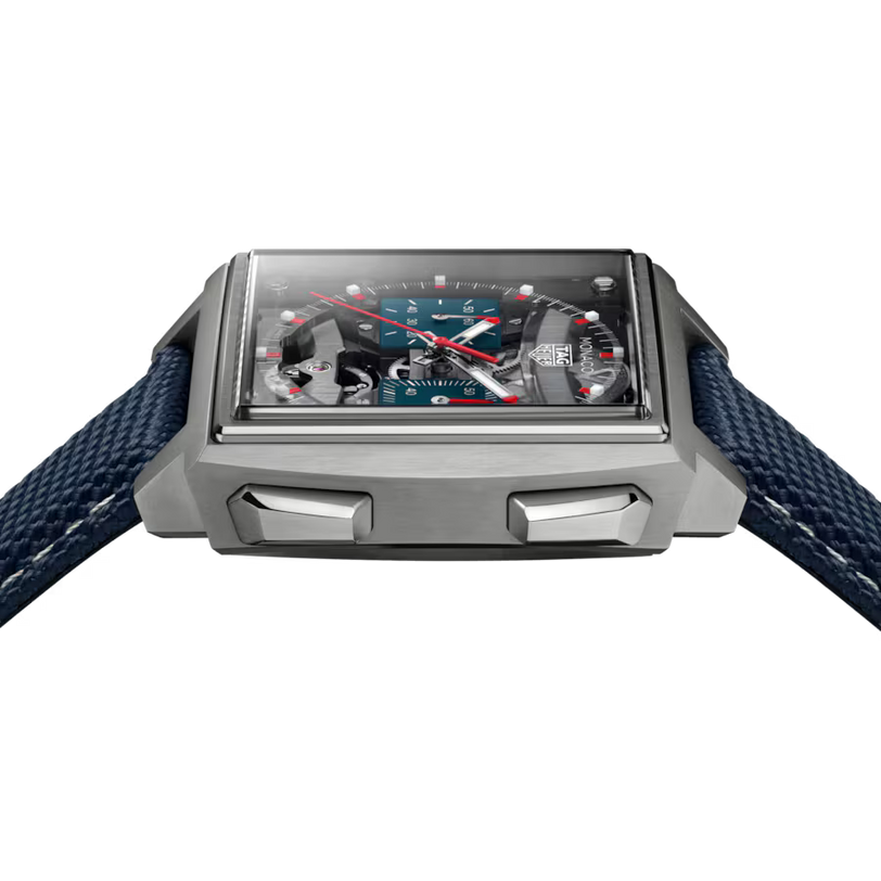 Rectangular watch with gray metal case, dark blue fabric strap, and rectangular dial featuring blue face with red hands and v