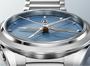 Silver watch with a blue face on a light gray background