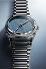 Silver watch with a blue face on a gradient background