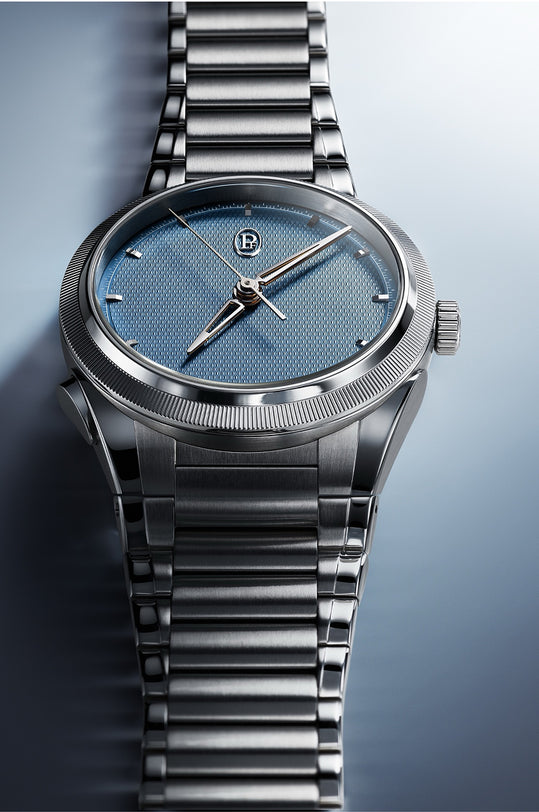 Silver watch with a blue face on a gradient background