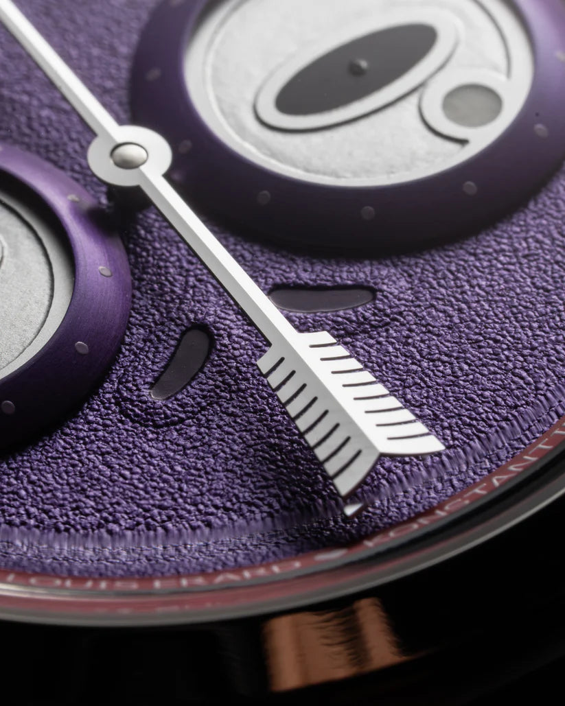 Close-up of a purple textured surface with a silver arrow design