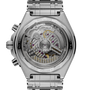 Stainless steel chronograph watch with visible mechanical movement through transparent caseback, metal bracelet, and chronogr
