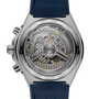 Stainless steel watch with visible mechanical movement, purple jewels, gold accents, and blue rubber strap shown from case ba
