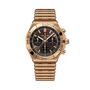 Gold-tone chronograph watch with black dial, three subdials, tachymeter bezel, and matching bracelet strap.