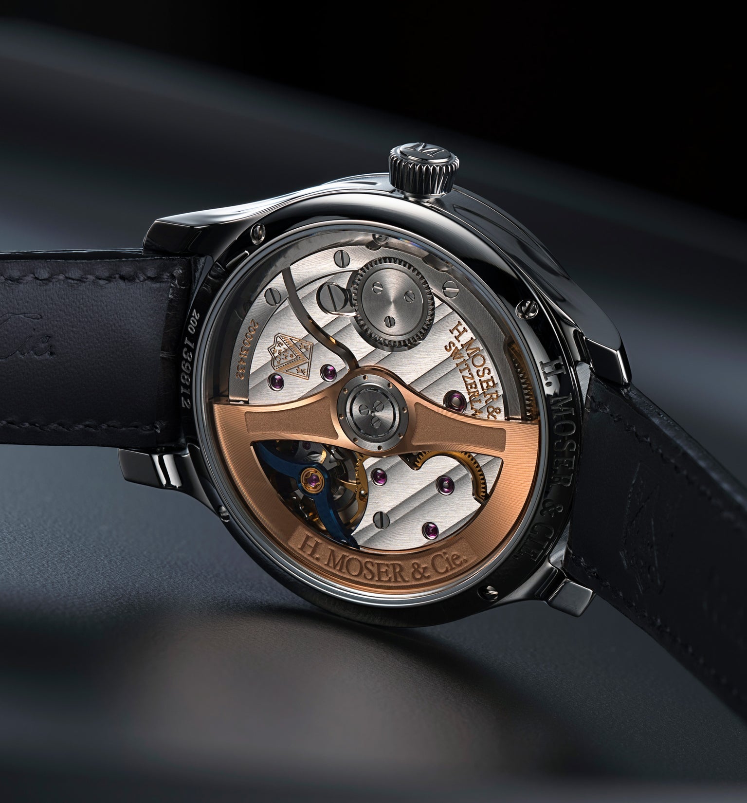 Stainless steel watch with open caseback displaying rose gold rotor, blue accents, and leather strap.