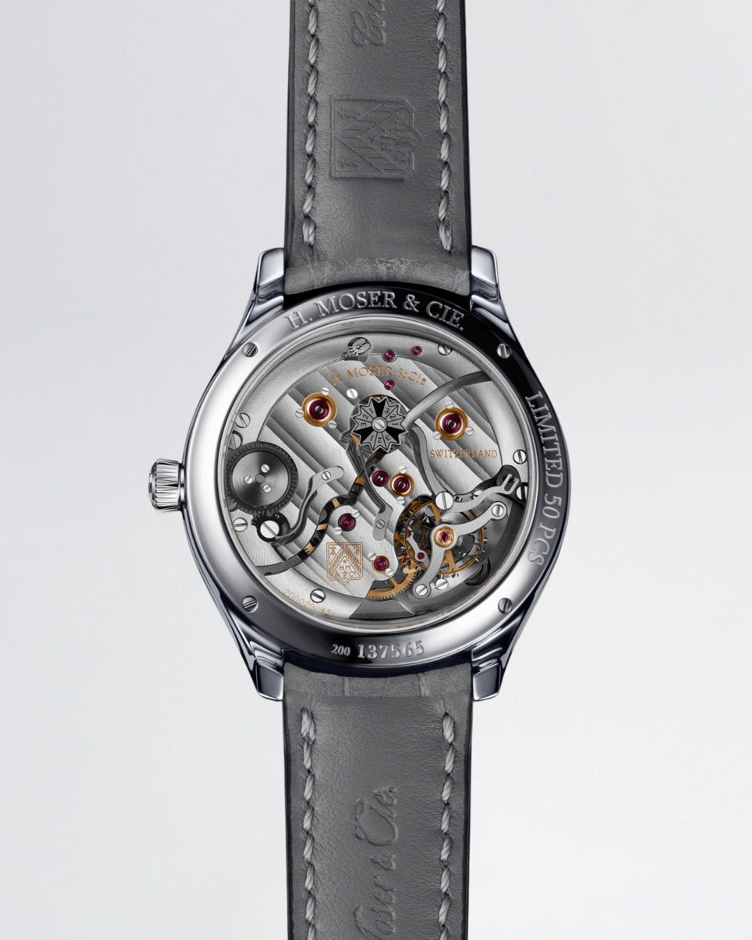 Stainless steel skeleton watch with visible tourbillon, ruby jewels, and H. Moser & Cie branding on gray leather strap.