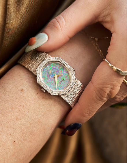 Luxury watch with a colorful face on a wrist, close-up shot.