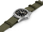 Watch with green strap and black dial on a white background