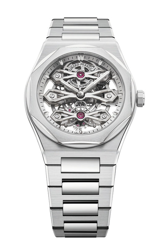 The Girard-Perregaux Laureato Three Gold Bridges is a luxury silver wristwatch featuring a stainless steel bracelet and an openwork skeleton dial that showcases intricate gears, components, and a tourbillon. The brand’s name appears at the top of the dial.