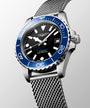 Longines watch with blue bezel and silver mesh band on a light gray background