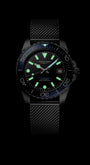 Black wristwatch with glowing face on a black background