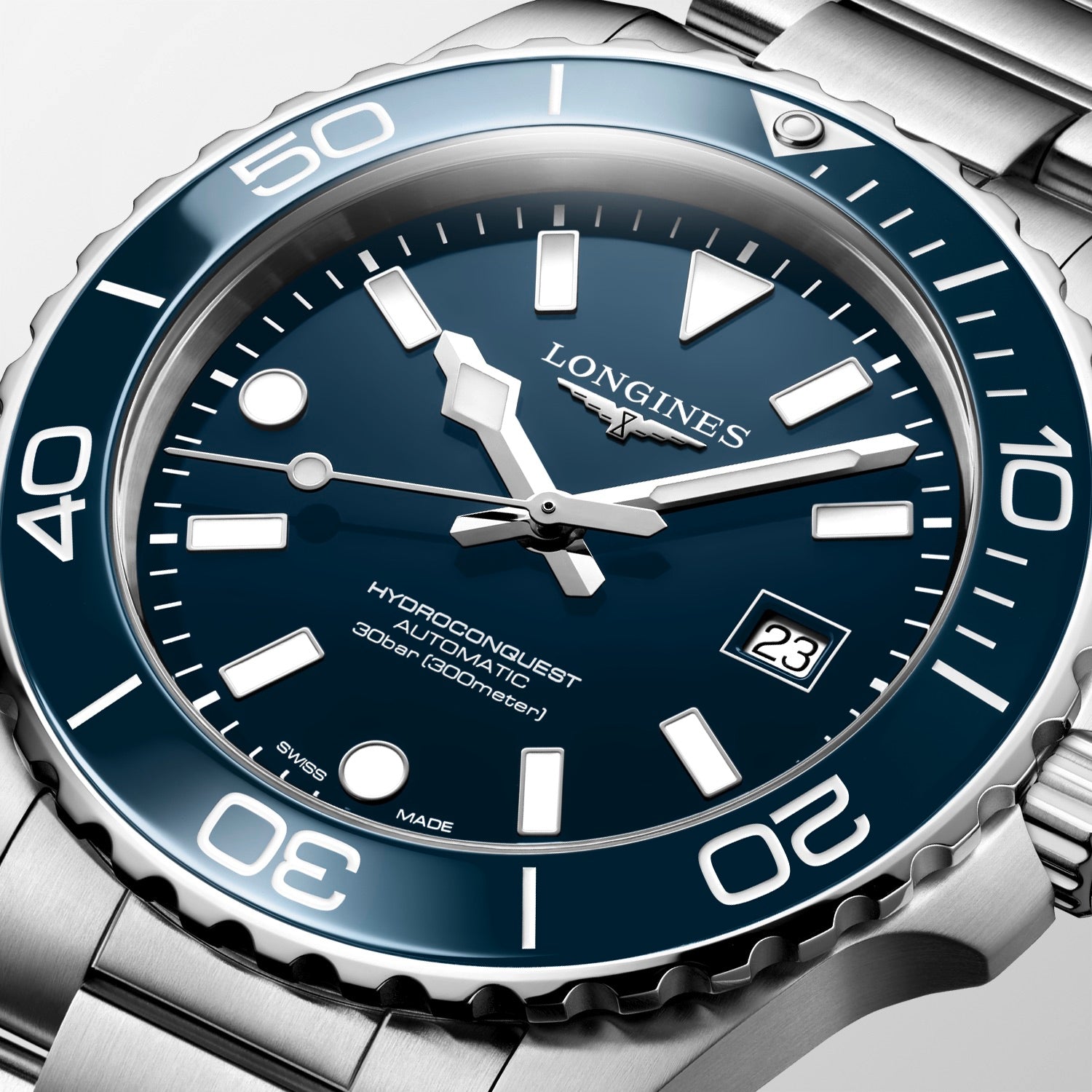 Longines watch with blue dial and silver case on a light gray background