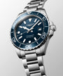 Longines watch with blue dial and silver bracelet on a light gray background