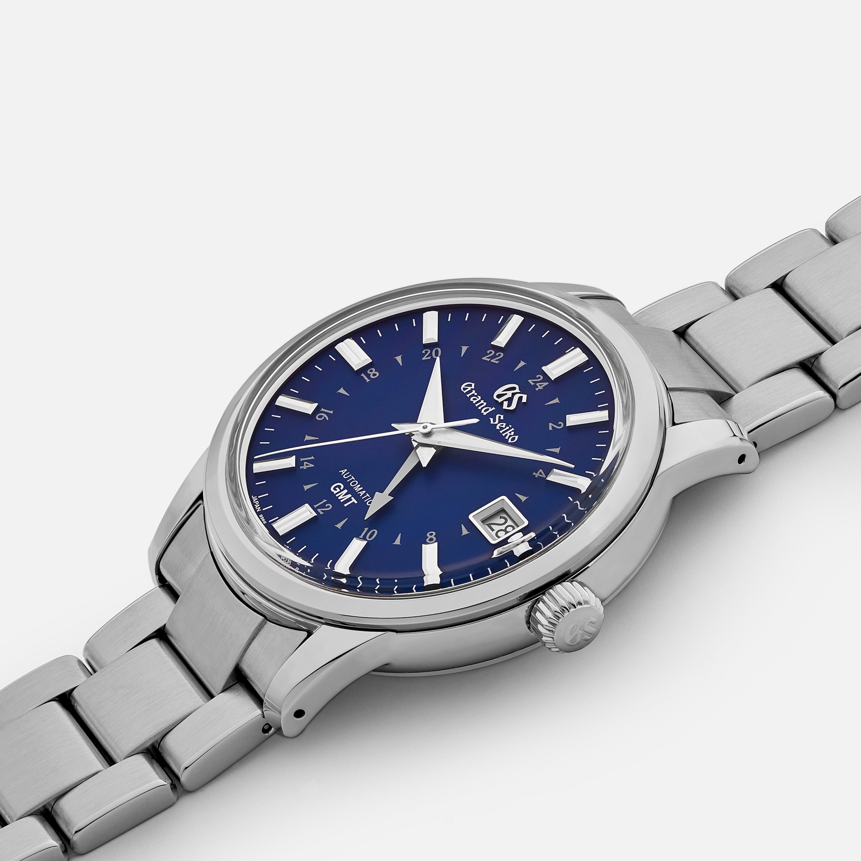 A Grand Seiko Automatic GMT SBGM239 Limited Edition for HODINKEE wristwatch features a stainless steel case, blue dial, silver markers, date window at 4 o’clock, and metal bracelet, shown against a plain white background.