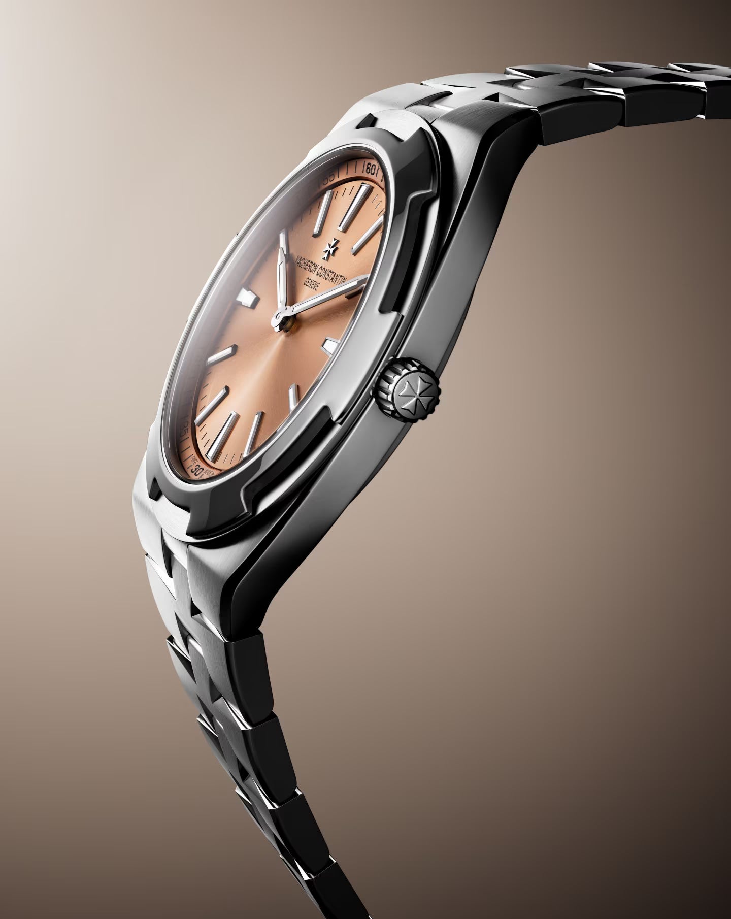 Two-tone stainless steel watch with salmon dial, applied indices, and matching bracelet displayed at an angle.