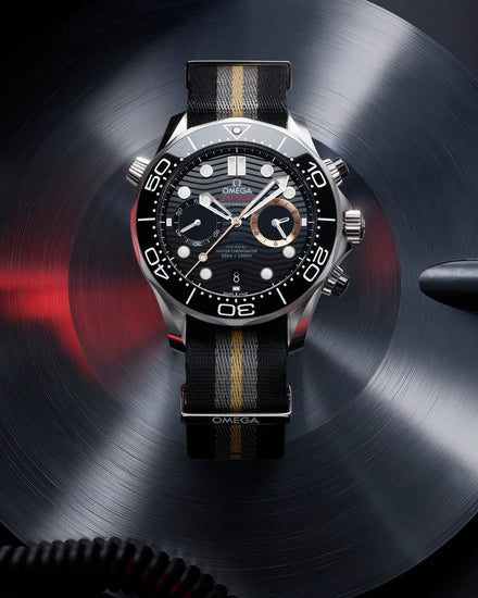Luxury watch with black dial and leather strap on a dark background