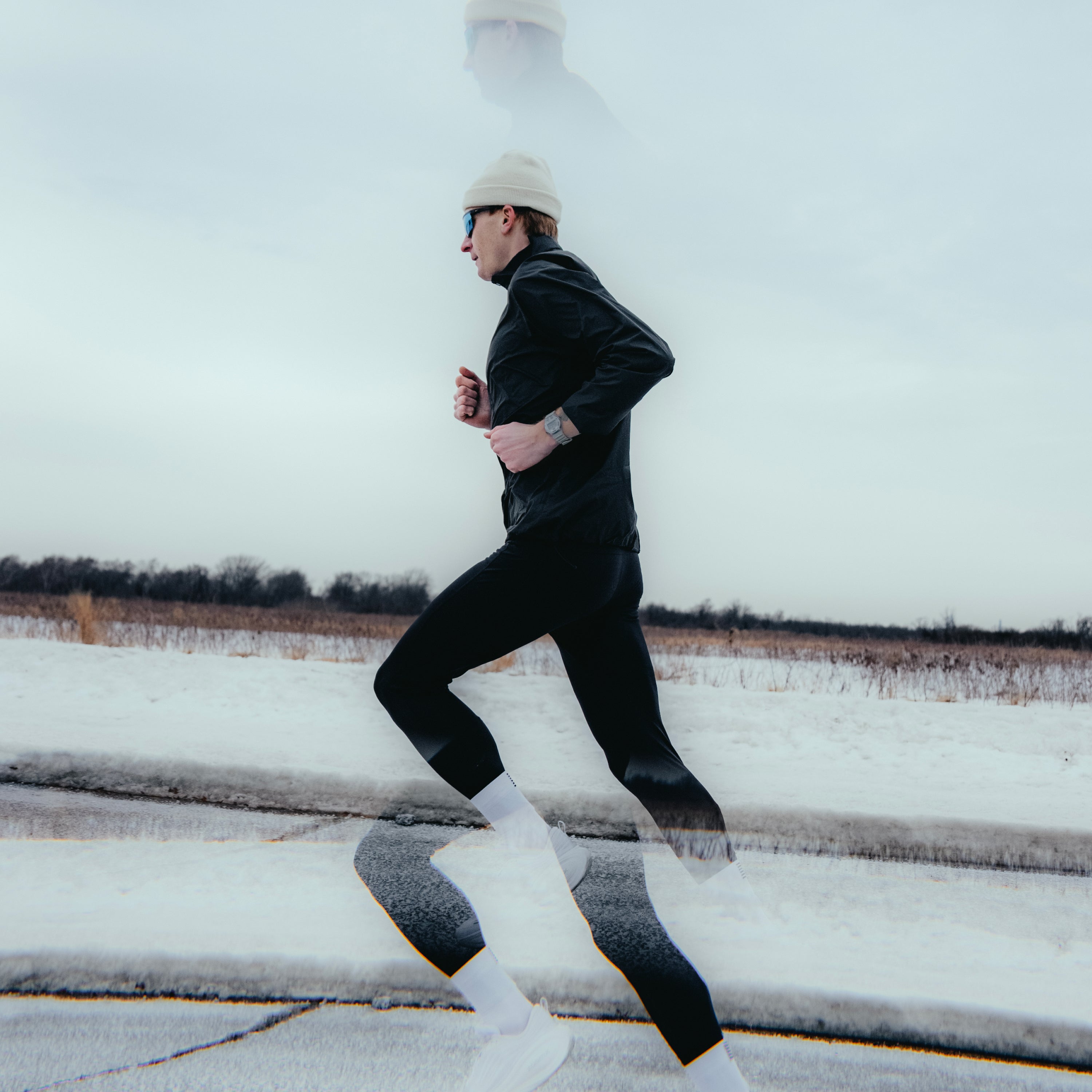 Person running on a snow-covered road with a white sky