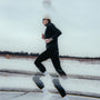Person running on a snow-covered road with a white sky