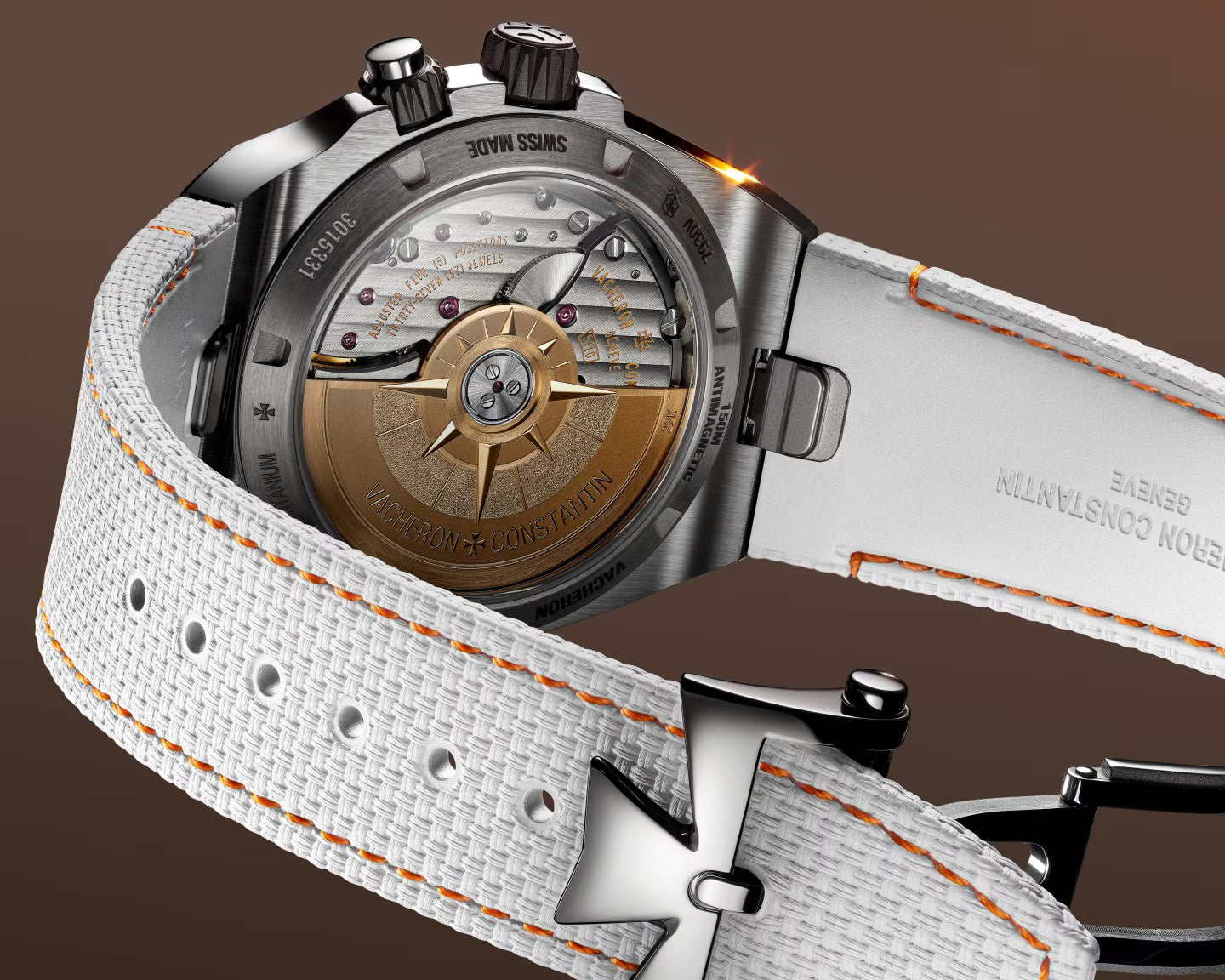 Stainless steel chronograph watch with bronze dial featuring ship's wheel design and white fabric strap with orange stitching
