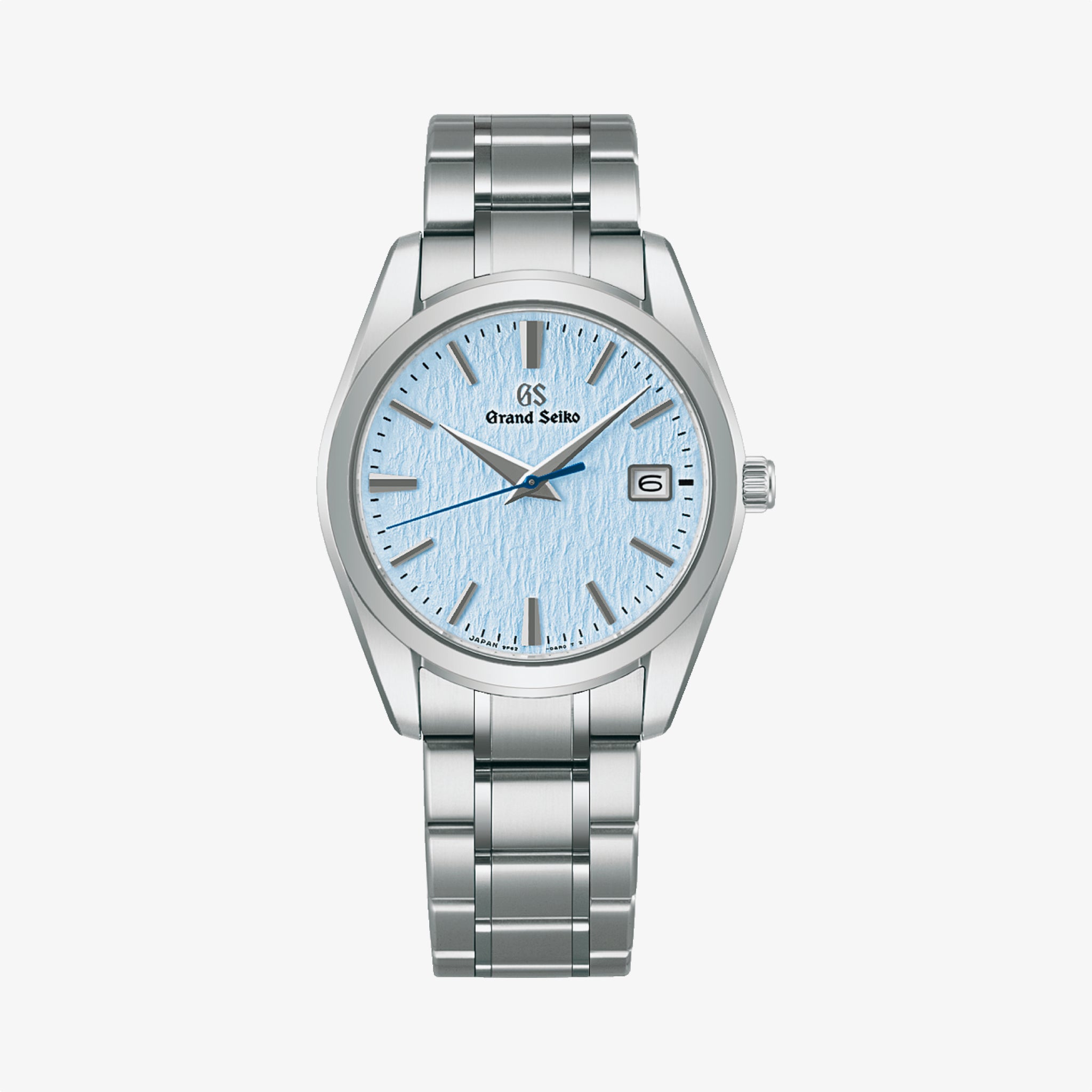 The Grand Seiko Heritage Quartz Snowflake is a silver wristwatch featuring a light blue textured dial, silver hour markers and hands, date at 3 o’clock, precise quartz caliber 9F62 movement, and a stainless steel bracelet.
