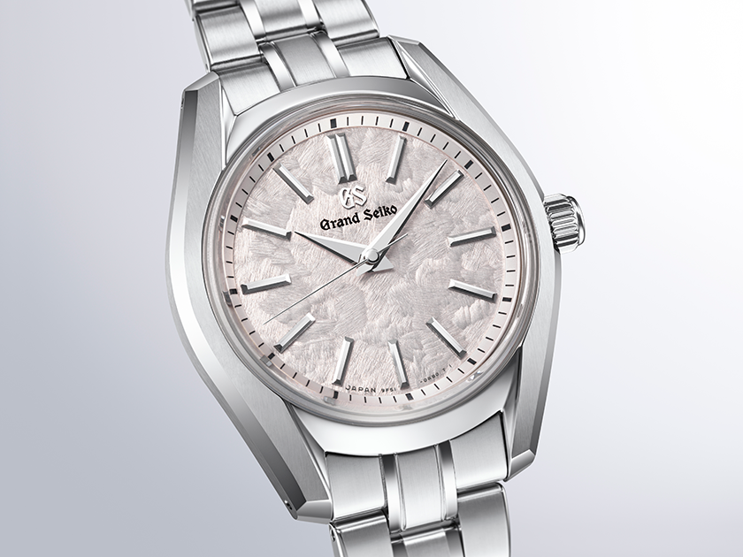 Grand Seiko stainless steel watch with silver textured dial, applied hour markers, and three-link bracelet.