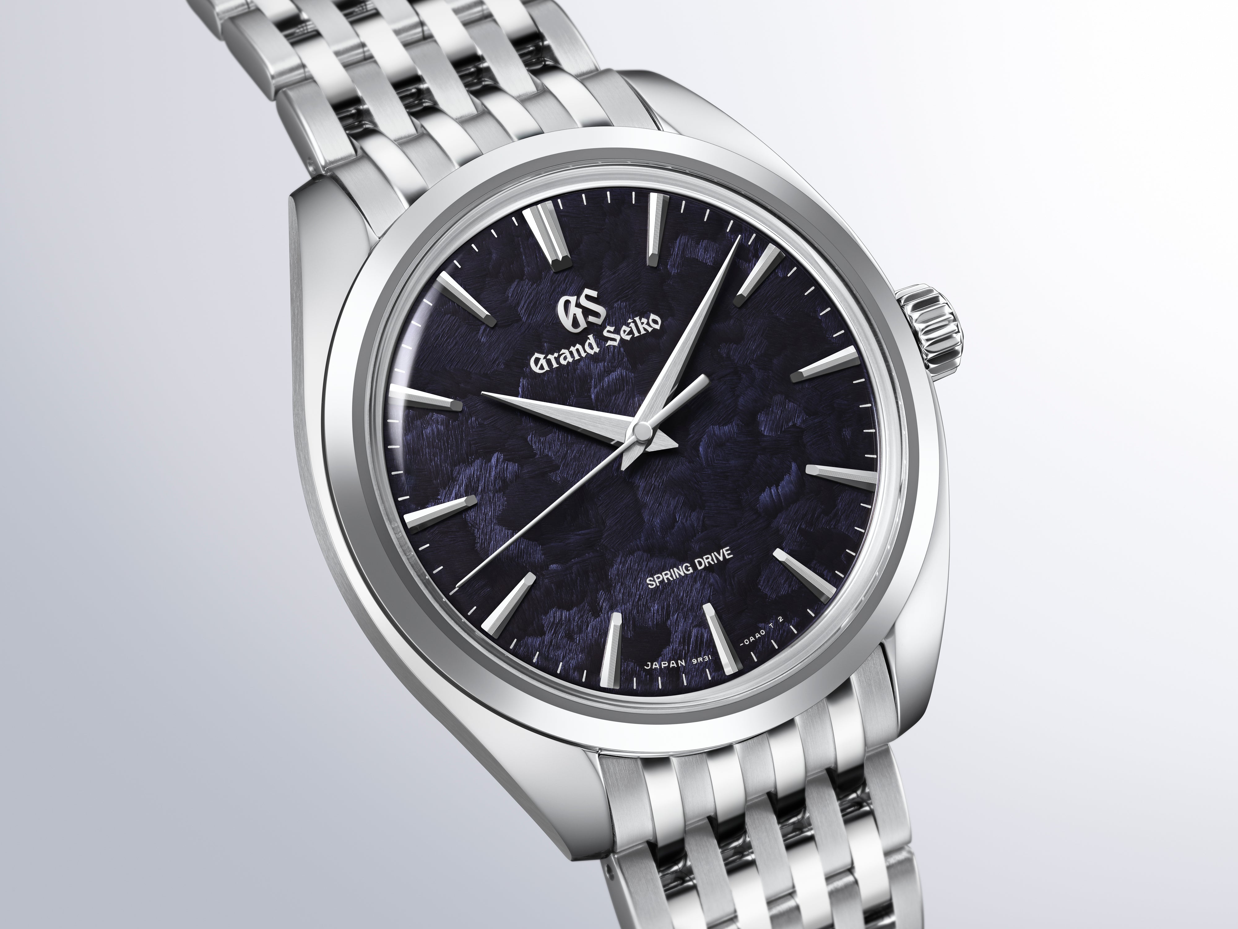 Grand Seiko watch with silver stainless steel bracelet, dark blue dial, and applied hour markers.