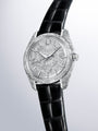 Silver watch with textured case and dial, black crocodile leather strap, applied indices and hands.