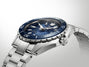 Stainless steel diver watch with dark blue dial, rotating bezel, and matching metal bracelet displayed against neutral backgr