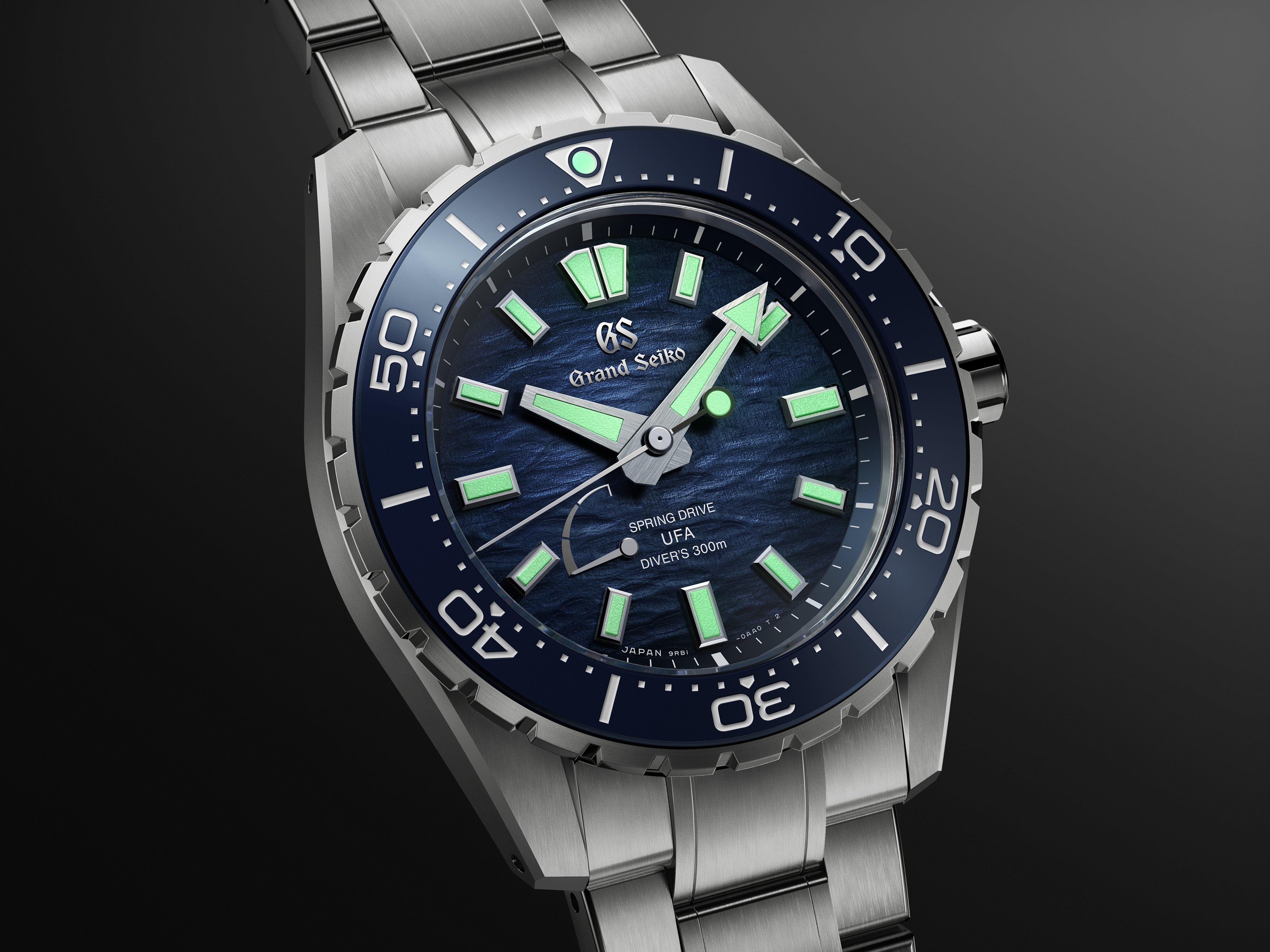 Silver stainless steel diver watch with dark blue dial, luminous hour markers, and matching bezel.