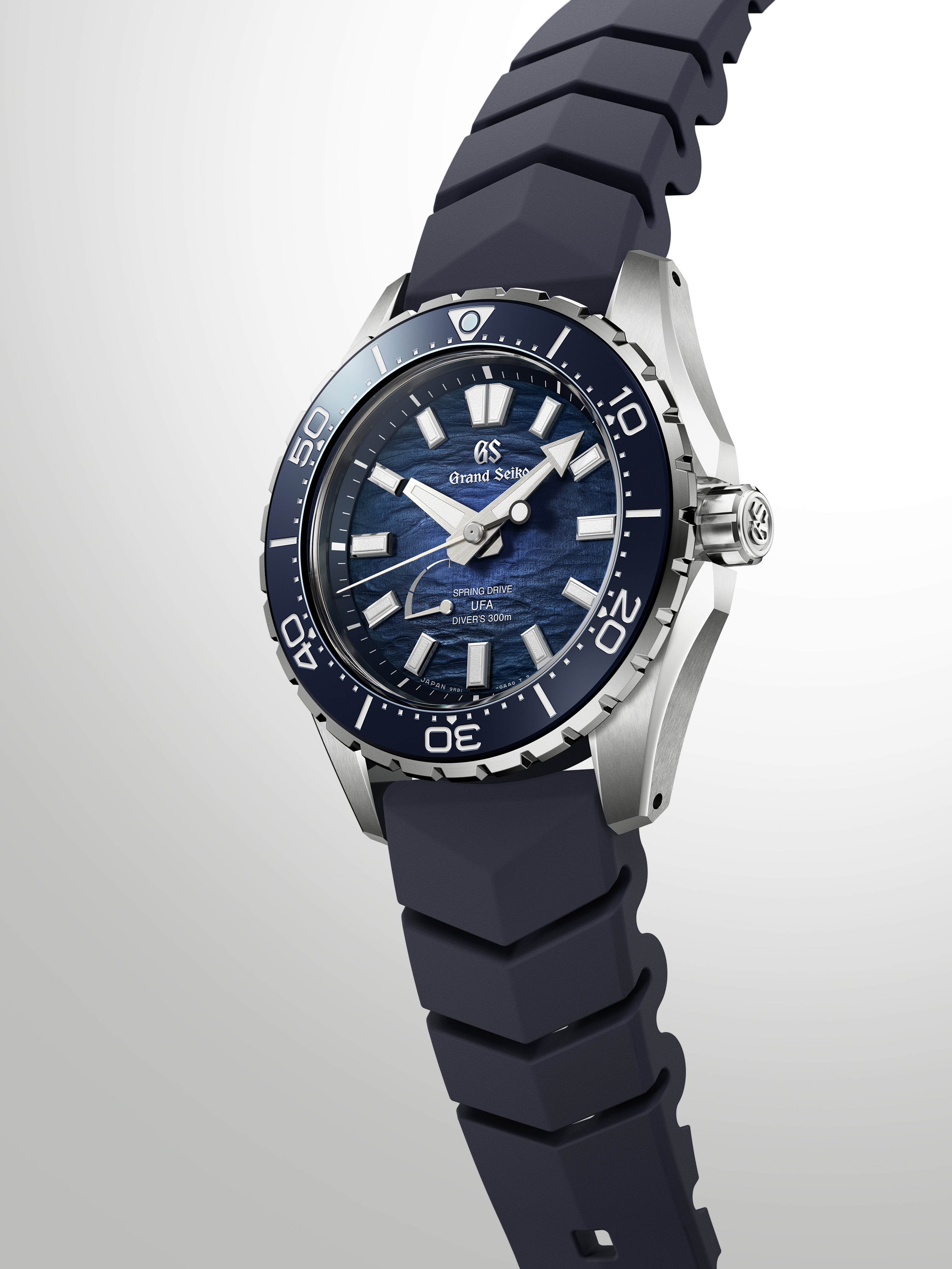 Grand Seiko diver watch with blue dial, silver case, black rubber strap, and rotating bezel.