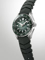 Grand Seiko diving watch with green dial, steel case, black rubber strap, and rotating bezel.