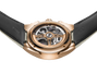 A close-up of the Parmigiani Fleurier TONDA PF Sport, showcasing its exposed mechanical movement in a rose gold case with a black leather strap.