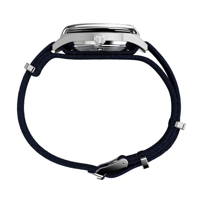 Side view of the Timex Marlin® Jet Automatic watch, featuring a silver case, dark blue fabric strap, retro-futuristic design, domed Hesalite crystal, distinctive clasp, and crown with logo.