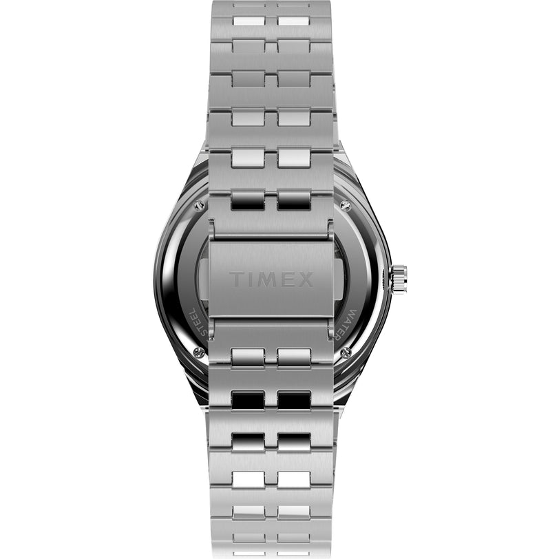 The Timex M79 Automatic x Peanuts wristwatch is shown from the back, featuring a stainless-steel bracelet with the TIMEX logo engraved on the clasp and a sleek brushed metal finish on its case and band.