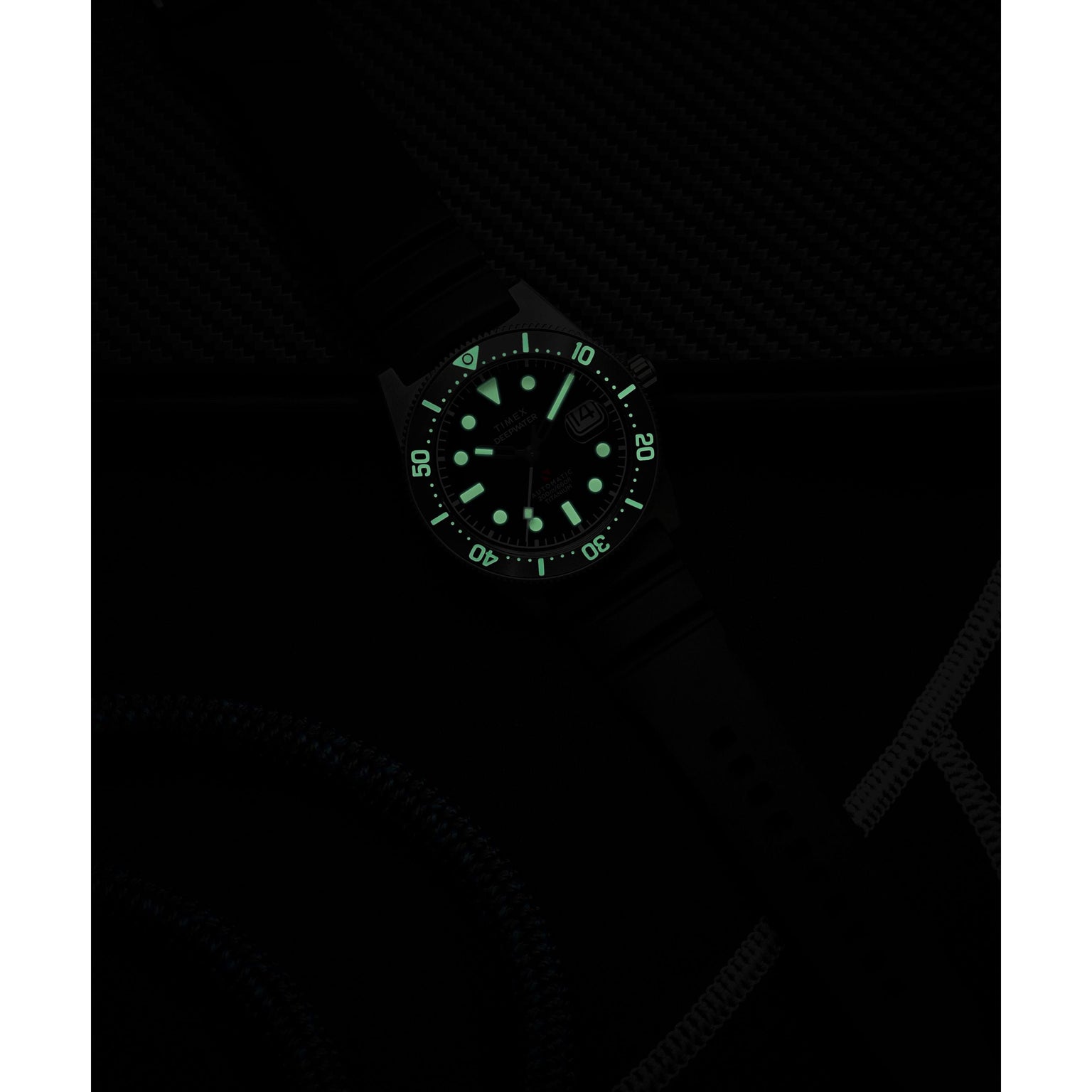 The Timex G TI AU SW DEEP WTR REEF 41 BLAK DL 25 is a titanium automatic dive watch with glowing green markers and numbers for visibility in darkness, a black strap and dial, plus 200m water resistance.