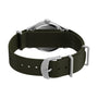 A close-up of the G SS MW SW MK1 36 BLK DL GRN STP 25 shows its military style with an olive green recycled fabric strap, a silver case, and a buckle engraved with the Timex brand.