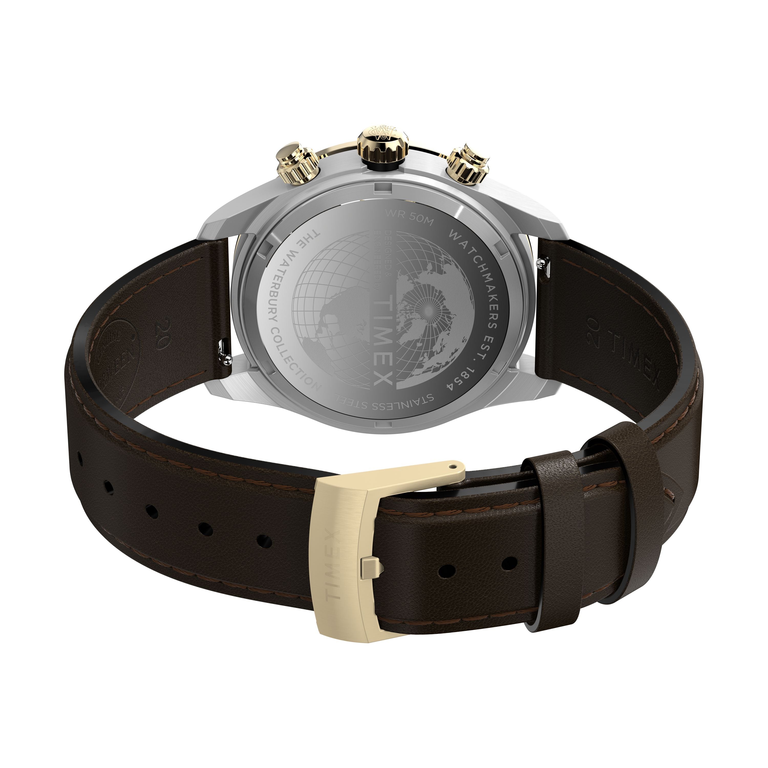 A close-up of the Timex Waterbury Heritage Chronograph shows its brown leather strap with gold buckle and a stainless-steel case back engraved with markings and a globe design.