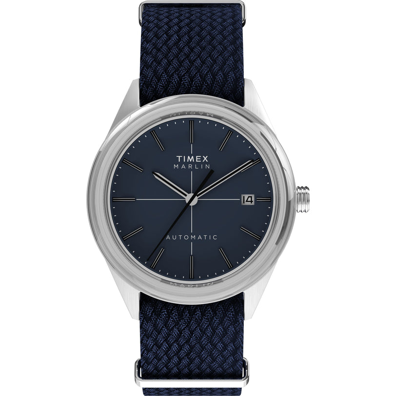 The Timex Marlin® Jet Automatic features a blue woven strap, silver case, dark blue dial with silver hour markers, three hands, date window at 3 o’clock, and a domed Hesalite crystal for retro-futuristic style.