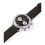 A Timex G SS QZ SW JET 40 BROWN DL BWN STP 25 watch with a silver case, black face, domed Hesalite crystal, two white subdials, chronograph and date display, and a dark brown leather strap is shown angled on a white background.