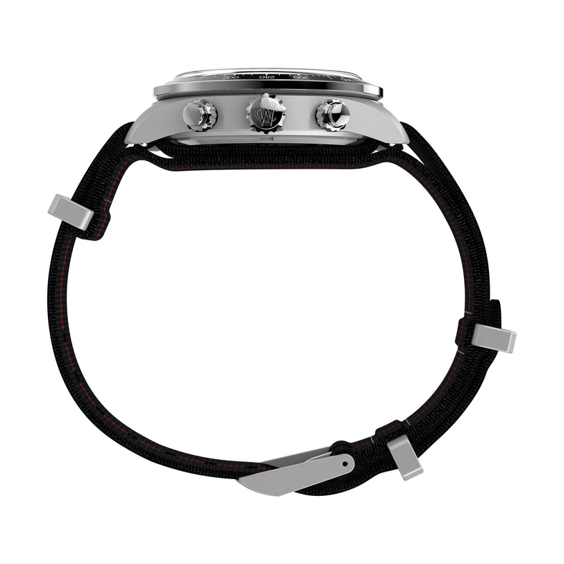 Side view of the Timex Waterbury Heritage Chronograph watch, featuring a silver case, three buttons, and a black recycled fabric strap with metal loops and buckle, shown against a white background.