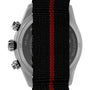 The Timex G SS QZ WTRBY HERT 39 BLK DL FABR STP 25 features two pushers and a crown, with its back partially covered by a recycled fabric strap showcasing a striking red central stripe.