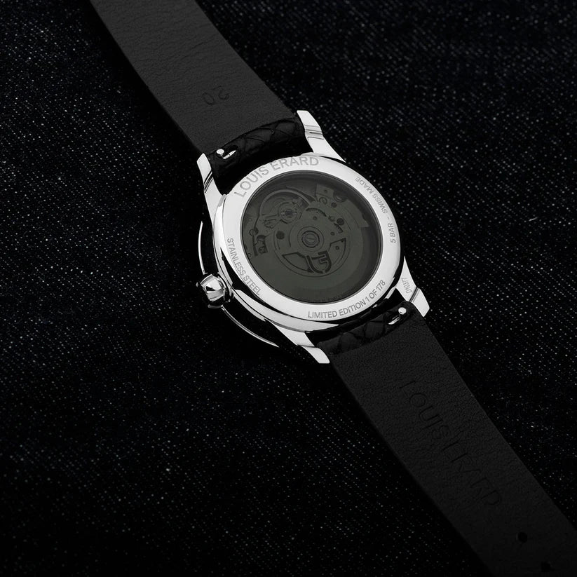 Watch with black strap and visible brand name on a dark textured background