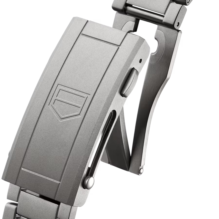 Stainless steel watch bracelet and clasp with shield-shaped logo detail, shown from side angle.