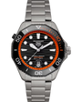 TAG Heuer Aquaracer watch with black dial, orange bezel, steel bracelet, and date window at 6 o'clock.