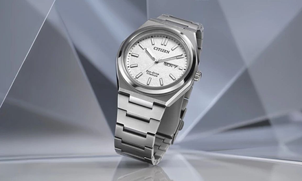 Silver Citizen watch on a reflective surface with a geometric background