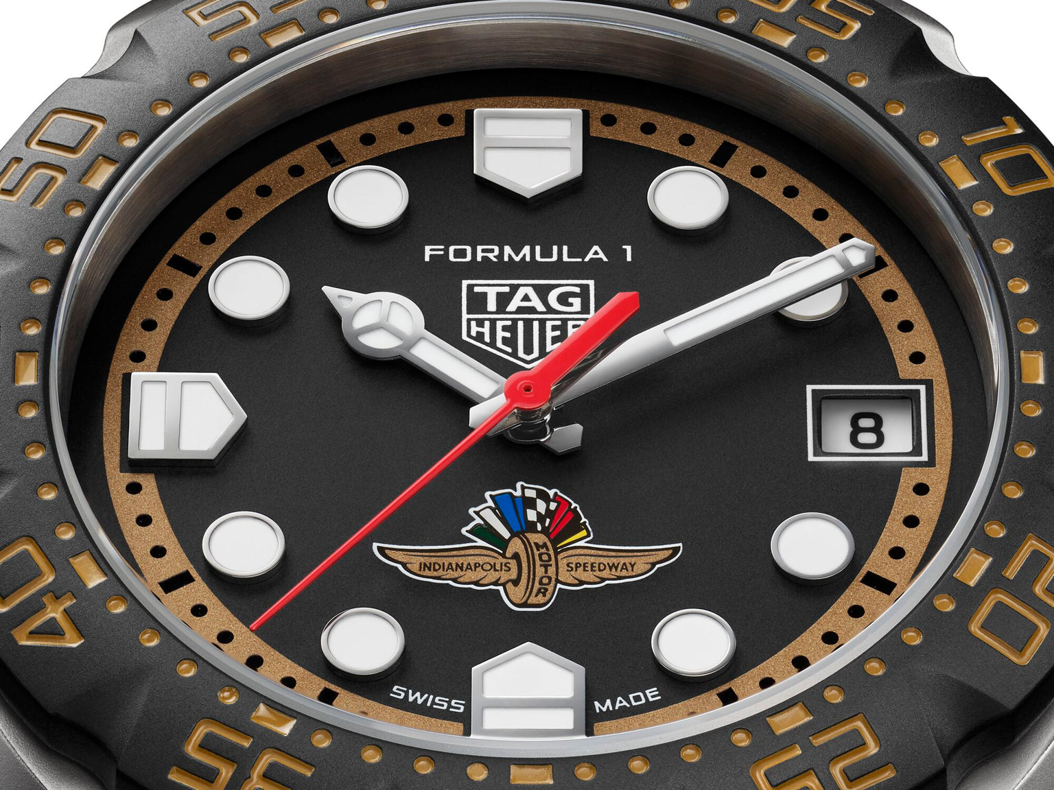TAG Heuer Formula 1 watch with black dial, white hour markers, red hands, Indianapolis 500 logo, and bronze-toned bezel with 