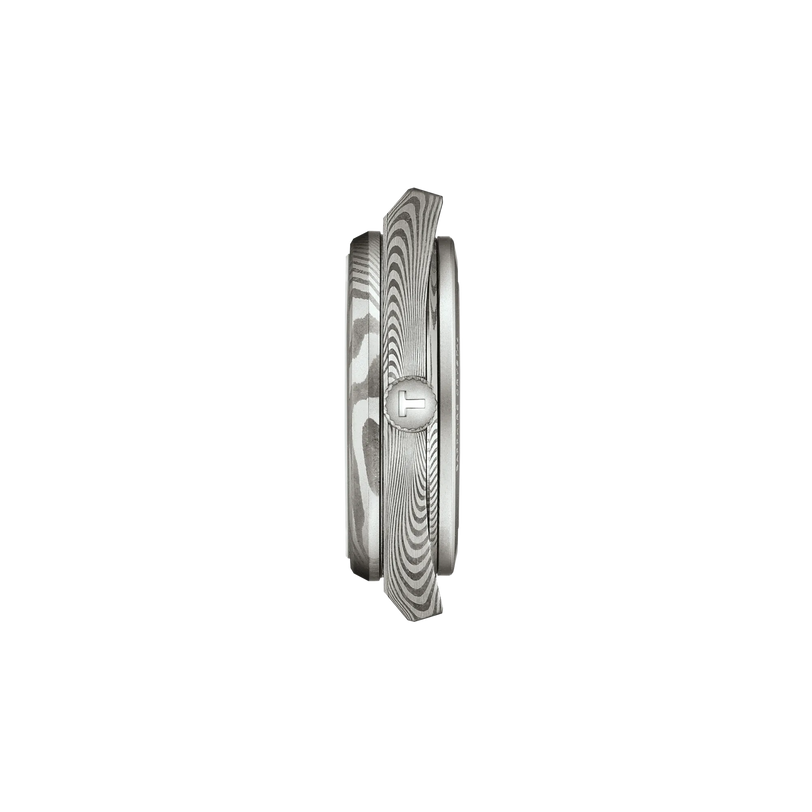 Side view of the Tissot PRX 38, featuring a marbled stainless steel finish with wavy, woodgrain-like patterns and a small rectangular accent, displayed against a plain white background.