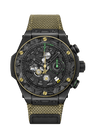Black ceramic chronograph watch with gold-tone bezel, green accents, skeleton dial, and yellow-gold woven fabric strap.