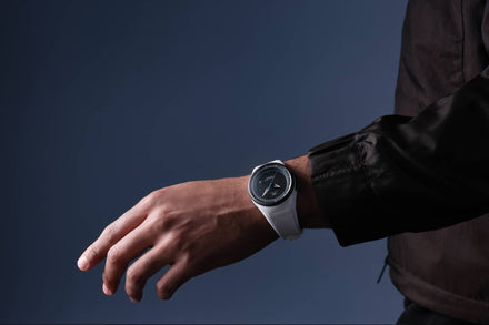 Person wearing a smartwatch on a dark background