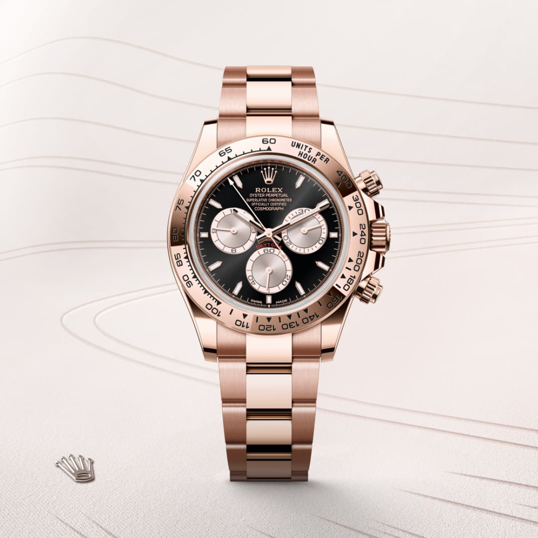 A rose gold Rolex wristwatch with a black dial and three subdials, displayed against a light background.